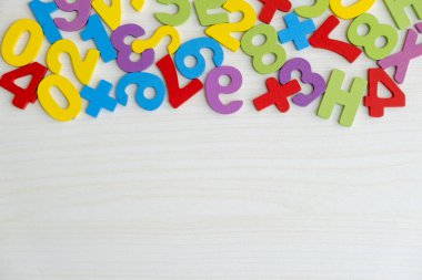 Tahta masaya saçılmış renkli ahşap sayılar ve harflerin üst görüntüsü