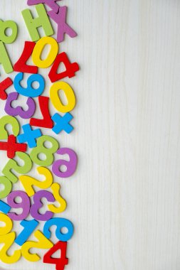 Tahta masaya saçılmış renkli ahşap sayılar ve harflerin üst görüntüsü