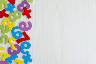 Tahta masaya saçılmış renkli ahşap sayılar ve harflerin üst görüntüsü