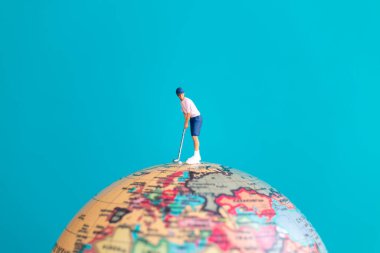 Küresel spor, seyahat ve hayal gücünü sembolize eden bir golfçünün minyatür figürü..