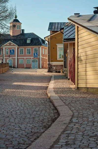 Cobblestone roads in old town Porvoo, Finland. Many colorful wooden houses and buildings like shops, cafes, museums and residential houses. Sunlight peeking through the buildings.