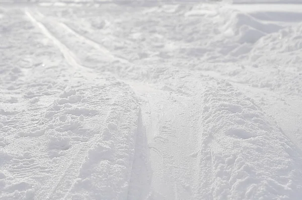 Close-up of a ski track or ski trail in the snow on a cold winter day. Skiing is a good outside winter activity and exercise practice.
