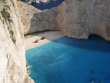 Yunanistan 'ın Zakynthos adasındaki Navagio Sahili' nin (Batık Kumsalı) nefes kesici manzarası. Bu dünyaca ünlü koy dik kireçtaşı kayalıkları, canlı turkuaz suları ve beyaz kumların üzerinde duran paslı bir gemi enkazı barındırıyor. Yukarıdan çekilen resim yüksekliği