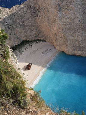 Yunanistan 'ın Zakynthos adasındaki Navagio Sahili' nin (Batık Kumsalı) nefes kesici manzarası. Bu dünyaca ünlü koy dik kireçtaşı kayalıkları, canlı turkuaz suları ve beyaz kumların üzerinde duran paslı bir gemi enkazı barındırıyor. Yukarıdan çekilen resim yüksekliği