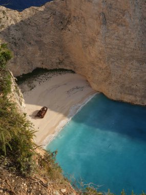 Yunanistan 'ın Zakynthos adasındaki Navagio Sahili' nin (Batık Kumsalı) nefes kesici manzarası. Bu dünyaca ünlü koy dik kireçtaşı kayalıkları, canlı turkuaz suları ve beyaz kumların üzerinde duran paslı bir gemi enkazı barındırıyor. Yukarıdan çekilen resim yüksekliği