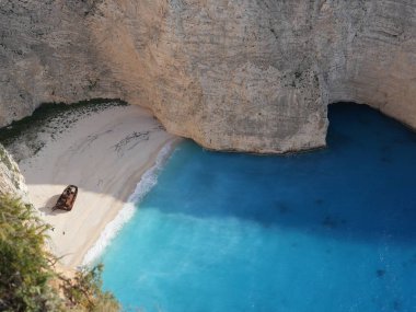 Yunanistan 'ın Zakynthos adasındaki Navagio Sahili' nin (Batık Kumsalı) nefes kesici manzarası. Bu dünyaca ünlü koy dik kireçtaşı kayalıkları, canlı turkuaz suları ve beyaz kumların üzerinde duran paslı bir gemi enkazı barındırıyor. Yukarıdan çekilen resim yüksekliği