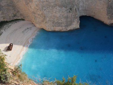 Yunanistan 'ın Zakynthos adasındaki Navagio Sahili' nin (Batık Kumsalı) nefes kesici manzarası. Bu dünyaca ünlü koy dik kireçtaşı kayalıkları, canlı turkuaz suları ve beyaz kumların üzerinde duran paslı bir gemi enkazı barındırıyor. Yukarıdan çekilen resim yüksekliği