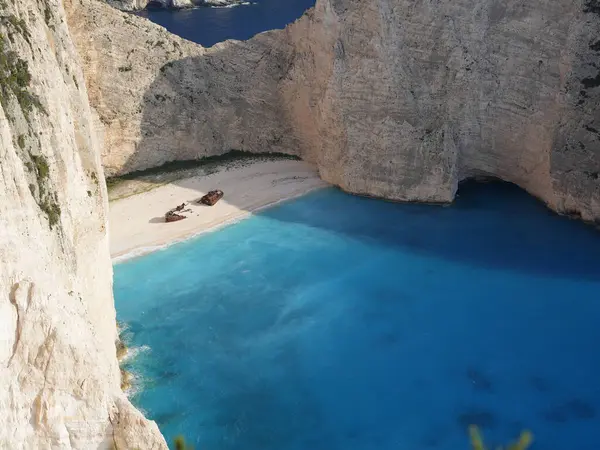Yunanistan 'ın Zakynthos adasındaki Navagio Sahili' nin (Batık Kumsalı) nefes kesici manzarası. Bu dünyaca ünlü koy dik kireçtaşı kayalıkları, canlı turkuaz suları ve beyaz kumların üzerinde duran paslı bir gemi enkazı barındırıyor. Yukarıdan çekilen resim yüksekliği