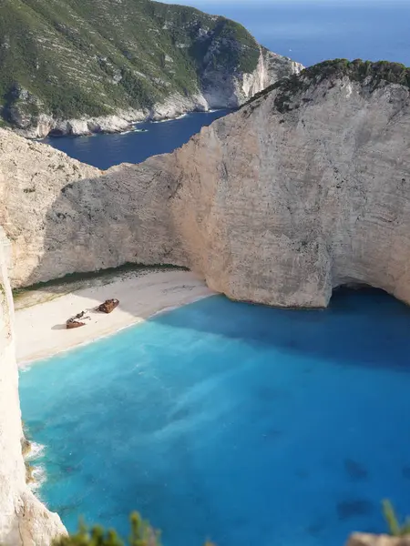 Yunanistan 'ın Zakynthos adasındaki Navagio Sahili' nin (Batık Kumsalı) nefes kesici manzarası. Bu dünyaca ünlü koy dik kireçtaşı kayalıkları, canlı turkuaz suları ve beyaz kumların üzerinde duran paslı bir gemi enkazı barındırıyor. Yukarıdan çekilen resim yüksekliği