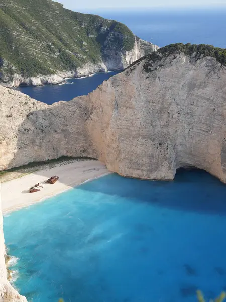 Yunanistan 'ın Zakynthos adasındaki Navagio Sahili' nin (Batık Kumsalı) nefes kesici manzarası. Bu dünyaca ünlü koy dik kireçtaşı kayalıkları, canlı turkuaz suları ve beyaz kumların üzerinde duran paslı bir gemi enkazı barındırıyor. Yukarıdan çekilen resim yüksekliği