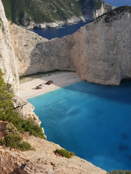 Yunanistan 'ın Zakynthos adasındaki Navagio Sahili' nin (Batık Kumsalı) nefes kesici manzarası. Bu dünyaca ünlü koy dik kireçtaşı kayalıkları, canlı turkuaz suları ve beyaz kumların üzerinde duran paslı bir gemi enkazı barındırıyor. Yukarıdan çekilen resim yüksekliği