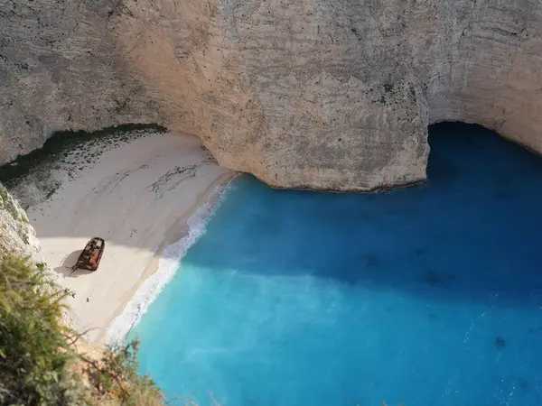 Yunanistan 'ın Zakynthos adasındaki Navagio Sahili' nin (Batık Kumsalı) nefes kesici manzarası. Bu dünyaca ünlü koy dik kireçtaşı kayalıkları, canlı turkuaz suları ve beyaz kumların üzerinde duran paslı bir gemi enkazı barındırıyor. Yukarıdan çekilen resim yüksekliği