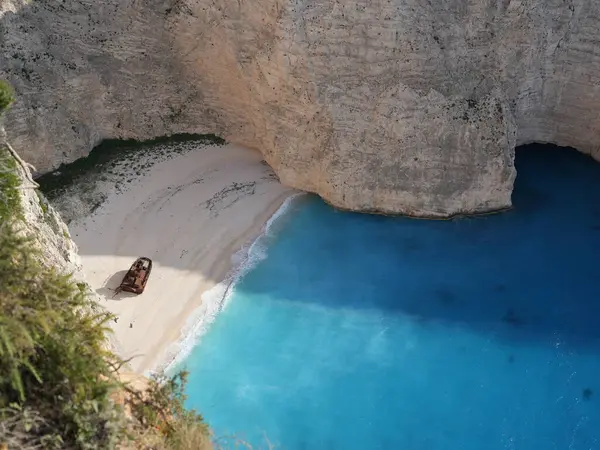 Yunanistan 'ın Zakynthos adasındaki Navagio Sahili' nin (Batık Kumsalı) nefes kesici manzarası. Bu dünyaca ünlü koy dik kireçtaşı kayalıkları, canlı turkuaz suları ve beyaz kumların üzerinde duran paslı bir gemi enkazı barındırıyor. Yukarıdan çekilen resim yüksekliği
