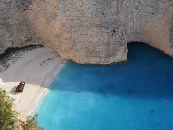 Yunanistan 'ın Zakynthos adasındaki Navagio Sahili' nin (Batık Kumsalı) nefes kesici manzarası. Bu dünyaca ünlü koy dik kireçtaşı kayalıkları, canlı turkuaz suları ve beyaz kumların üzerinde duran paslı bir gemi enkazı barındırıyor. Yukarıdan çekilen resim yüksekliği