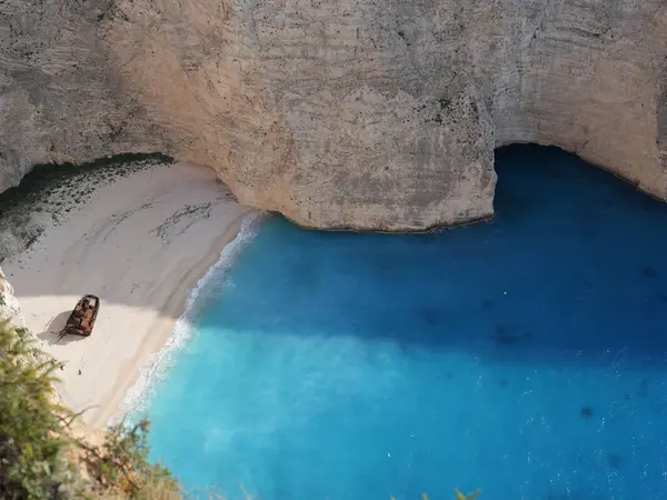 Yunanistan 'ın Zakynthos adasındaki Navagio Sahili' nin (Batık Kumsalı) nefes kesici manzarası. Bu dünyaca ünlü koy dik kireçtaşı kayalıkları, canlı turkuaz suları ve beyaz kumların üzerinde duran paslı bir gemi enkazı barındırıyor. Yukarıdan çekilen resim yüksekliği