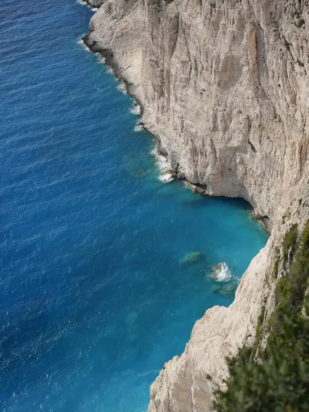 Yunanistan 'ın Zakynthos adasından çarpıcı bir kıyı manzarası, dik uçurumlara ve İyon Denizi boyunca görünen Mora Dağları' na bakan derin mavi denize bakıyor. Görüntü Akdeniz kıyılarının doğal güzelliklerini yakalıyor, engebeli araziyi birleştiriyor.