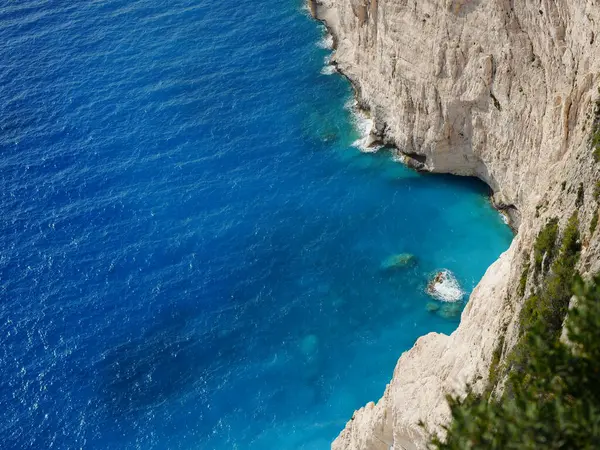 Yunanistan 'ın Zakynthos adasından çarpıcı bir kıyı manzarası, dik uçurumlara ve İyon Denizi boyunca görünen Mora Dağları' na bakan derin mavi denize bakıyor. Görüntü Akdeniz kıyılarının doğal güzelliklerini yakalıyor, engebeli araziyi birleştiriyor.