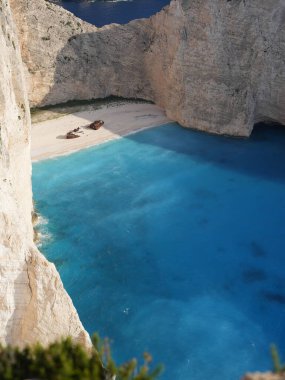 Yunanistan 'ın Zakynthos adasındaki Navagio Sahili' nin (Batık Kumsalı) nefes kesici manzarası. Bu dünyaca ünlü koy dik kireçtaşı kayalıkları, canlı turkuaz suları ve beyaz kumların üzerinde duran paslı bir gemi enkazı barındırıyor. Yukarıdan çekilen resim yüksekliği