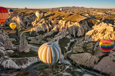 İnanılmaz Cappadocia kayalık manzarası ve gün doğumunda balonlar, vadi ve kanyonların manzarası.