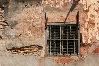 Malezya 'nın Penang kentindeki eski George Town kasabasında yıkık tuğla duvarda metal ızgaralar olan bir pencere..