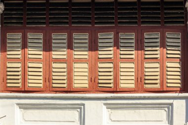 Georgetown, Penang, Malezya - Kasım 2012: Penang 'ın miras kasabasındaki eski bir mağaza evinin kahverengi dikdörtgen ahşap pencerelerinin ayrıntıları.