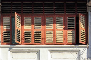 Georgetown, Penang, Malezya - Kasım 2012: Penang 'ın miras kasabasındaki eski bir mağaza evinin kahverengi dikdörtgen ahşap pencerelerinin ayrıntıları.