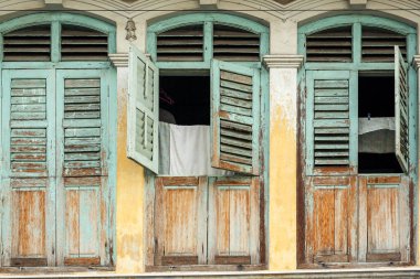 Malezya 'nın Penang kentindeki Georgetown' da eski bir Çin atölyesinin güzel, harap olmuş, ahşap pencereleri..