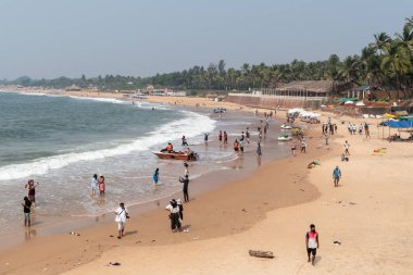 Candolim, Goa, Hindistan - Ocak 2023: Kuzey Goa 'daki Sinquerim' de turistlerle dolu plajın havadan görünüşü.
