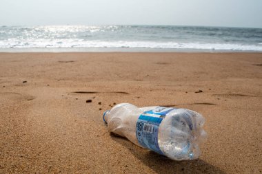 Candolim, Goa, Hindistan - Ocak 2023: Sinquerim 'de bir turist plajında duran plastik bir su şişesi.