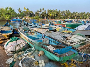 Sinquerim, Goa, Hindistan - Ocak 2023: Nerul Nehri kıyılarına demirlemiş balıkçı tekneleri ve balıkçı ağları.