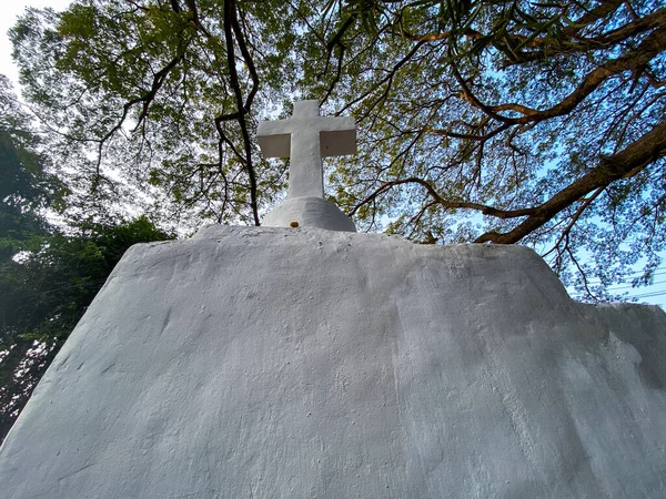 果阿一座被树木环绕的小礼拜堂白色交叉口的低角度图像 — 图库照片