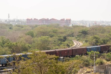 Hassan, Karnataka, Hindistan - 9 Ocak 2023: Bir kasabanın yeşil mahallesinden geçen trenin hava görüntüsü.