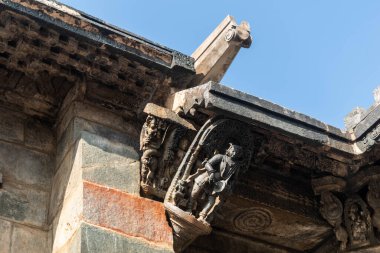 Beautiful ornate carving of a figurine on the wall of the ancient Chennakeshava temple in Belur. clipart