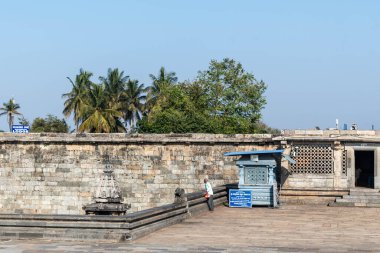 Belur, Karnataka, Hindistan - 9 Ocak 2023: Avludaki eski tank Chennakeshava Tapınağı kompleksinde palmiye ağaçları ile çevrili.