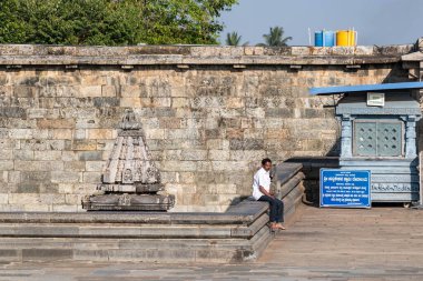 Belur, Karnataka, Hindistan - 9 Ocak 2023: Avludaki eski tank Chennakeshava Tapınağı kompleksinde palmiye ağaçları ile çevrili.