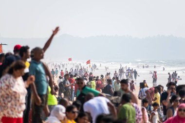 Calangute, Goa, Hindistan - Ocak 2023: Calangute sahilinin popüler turistik merkezinde tatil yapan insanlarla dolu kalabalık bir plaj.