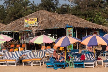 Calangute, Goa, Hindistan - Ocak 2023: Kafkas turistler Goa 'daki bir plaj barakasının plaj yataklarında dinleniyorlar.