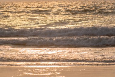 Akşam ışığı Goa 'daki bir sahilde okyanus dalgalarını vuruyor..