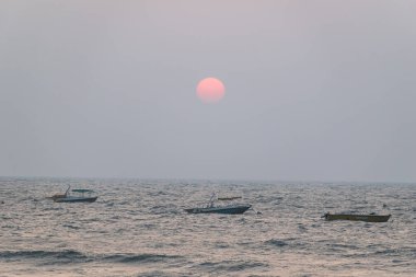 Calangute, Goa, Hindistan - Ocak 2023: Goa 'da denize açılan teknelerin üzerinde güneş battı.