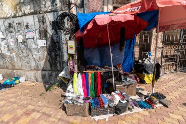 Margao, Goa, Hindistan - Ocak 2023: Madgaon şehrinde kaldırımda bir ayakkabı tamircisi.