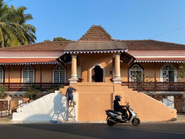 Margao, Hindistan - 21 Ocak 2023: Güney Goa 'da eski bir geleneksel evin duvarını boyayan bir adam.