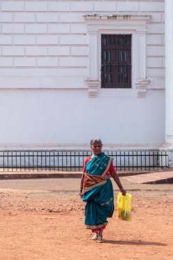 Eski Goa, Hindistan - Ocak 2023: Eski Goa 'daki Se Katedrali' nin dışında yürüyen yaşlı bir Hintli kadın.