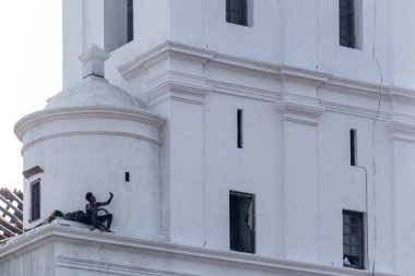 Eski Goa, Hindistan - Ocak 2023: Eski Goa 'daki antik Se Katedrali' nin çatısında oturan iki adam.
