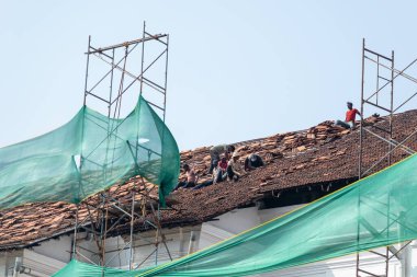 Eski Goa, Hindistan - Ocak 2023: Eski Goa 'daki Assisi Kilisesi' nin UNESCO miras alanının fayanslı çatısını restore eden işçiler.