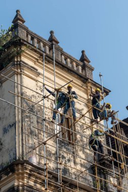Eski Goa, Hindistan - Ocak 2023: Eski Goa 'nın UNESCO miras sahasındaki Aziz John Kilisesi' nin onarımı ve restorasyonu üzerinde çalışan işçiler.