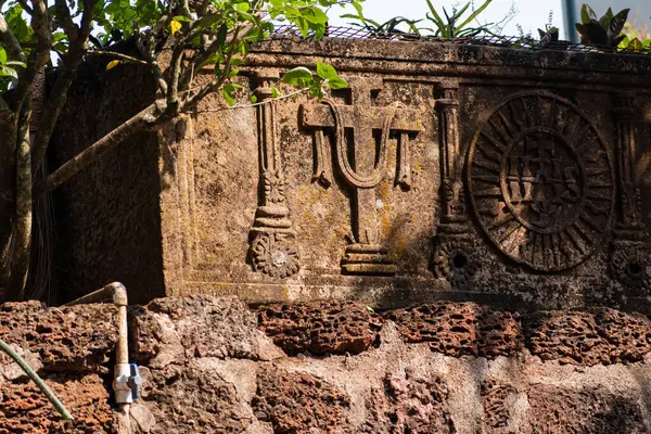 Eski bir Portekiz dönemi, Eski Goa 'nın UNESCO miras sahasındaki bir kilisenin kalıntılarına oyma yapıyor..