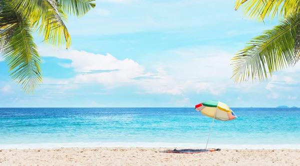 Zomer Strand Achtergrond Kleurrijke Paraplu Mat Zand Blauwe Lucht Zee Rechtenvrije Stockfoto's