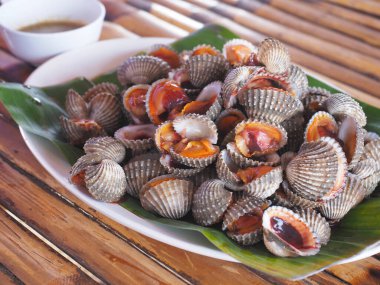 Yeşil muz yaprağında servis edilen haşlanmış midye ya da haşlanmış midye. Deniz ürünleri..