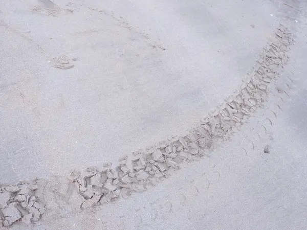Wheel tread marks in the sand on the beach. Tire track mark pattern.