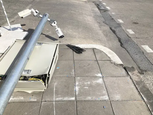 Fallen pole and broken CCTV camera on the footpath by car accident in the city.